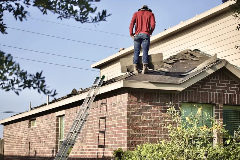 Professional roofer working on a residential roof in Camp Mishannock